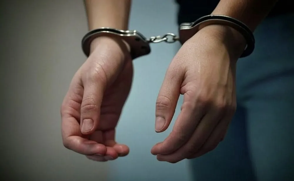 mujer esposada detenida