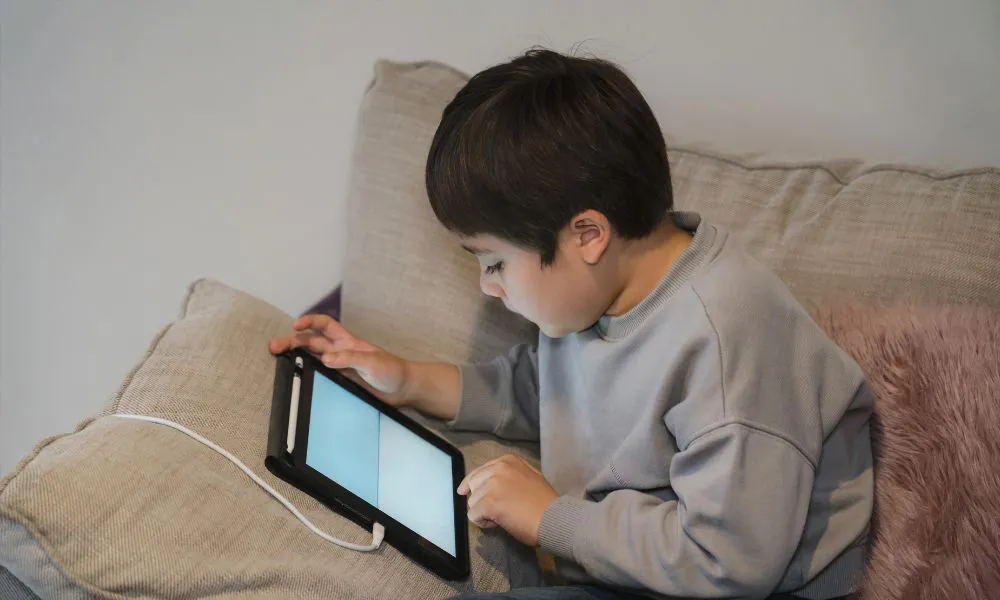 Niño usando un dispositivo electrónico foto Freepik