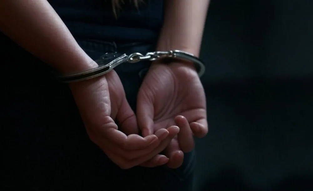 mujer esposada detenida Foto IA Grok