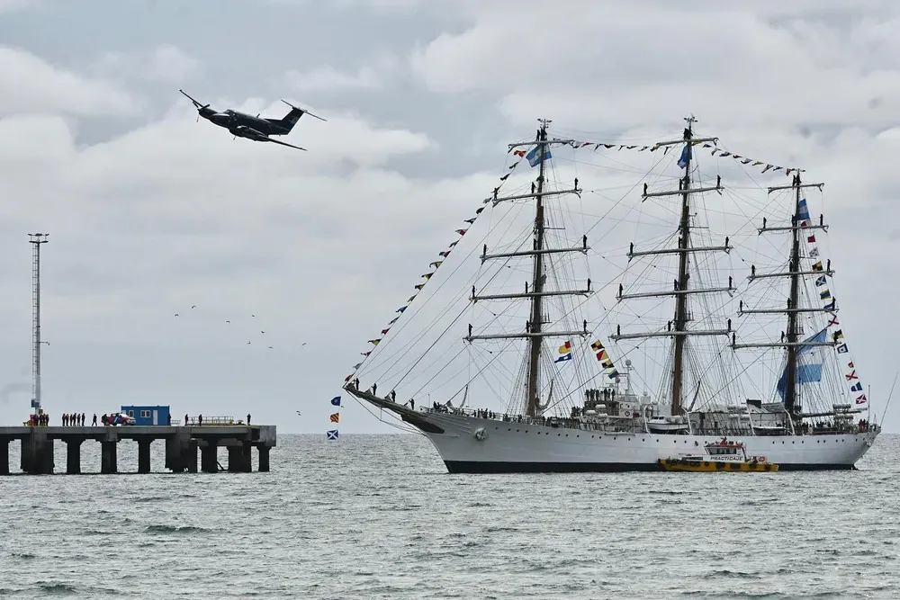 La Fragata Libertad llegando al Muelle Piedra Buena y escoltada desde el aire por un avión de la base de Trelew