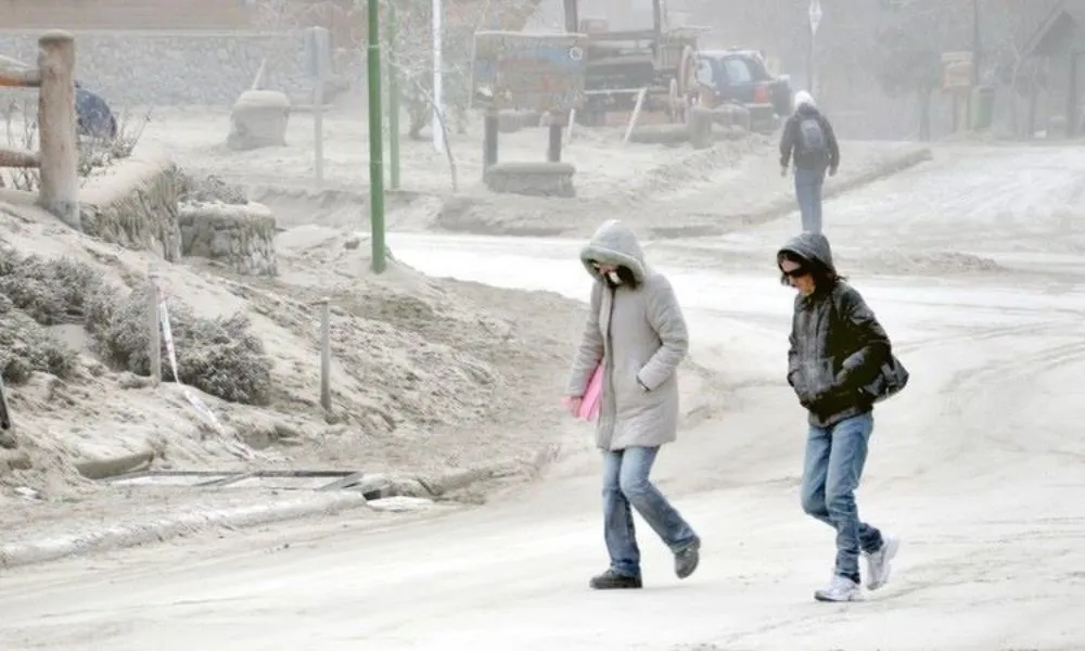 Gente caminando entre la ceniza del volcán