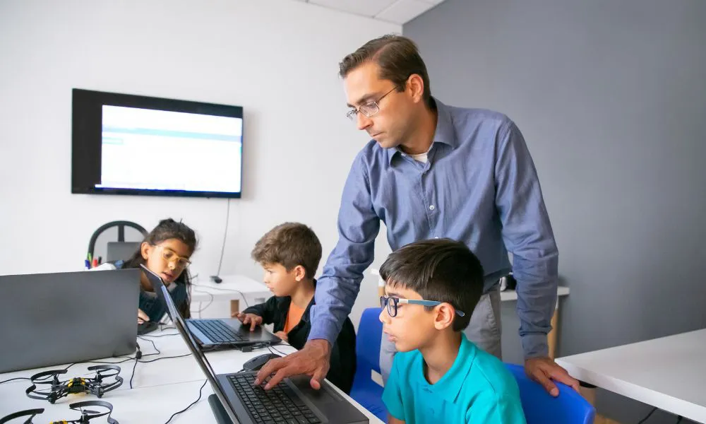 Alumnos en el aula con computadoras