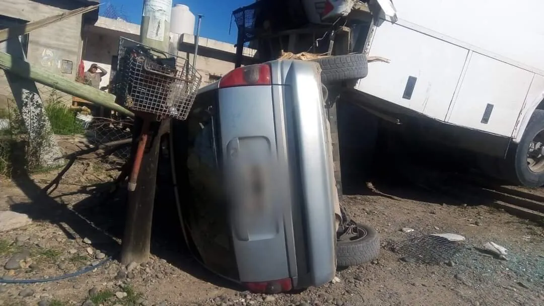 Auto debajo del colectivo afectado